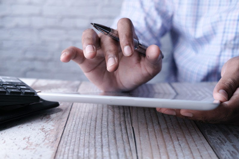 main-homme-travaillant-tablette-numerique-au-bureau-aide-graphique-auto-chèque-numérique